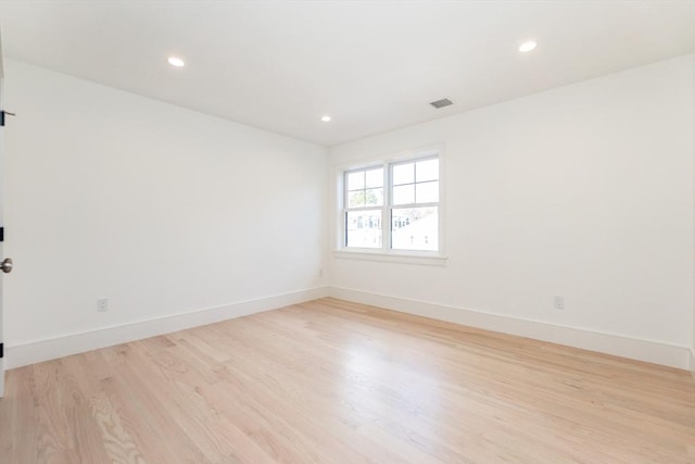 unfurnished room with light wood-type flooring, baseboards, visible vents, and recessed lighting