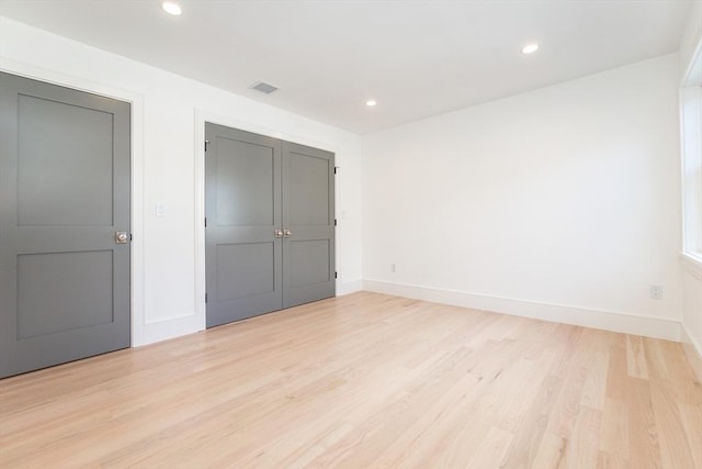 unfurnished bedroom with light wood-style floors, recessed lighting, and baseboards