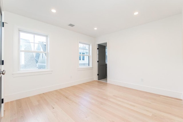 unfurnished room with light wood finished floors, recessed lighting, visible vents, and baseboards