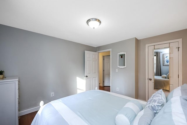 bedroom featuring baseboards and dark wood finished floors