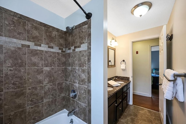 bathroom featuring double vanity, washtub / shower combination, baseboards, and a sink