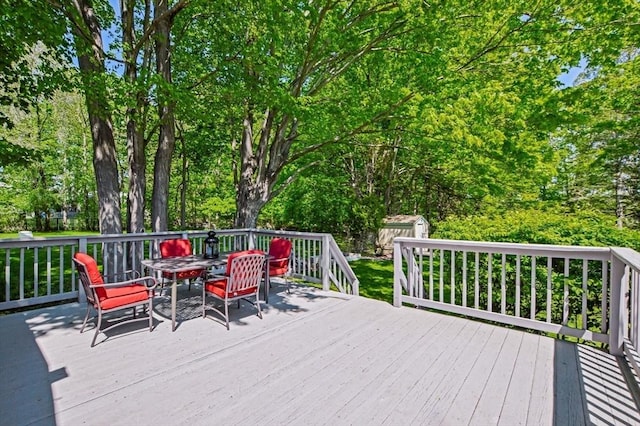 130 N Walker St, Taunton, MA 02780 - wooden deck with a shed, outdoor dining space, an outdoor structure, and view of wooded area