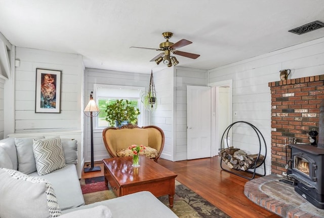130 N Walker St, Taunton, MA 02780 - living area featuring a wood stove, a ceiling fan, wood finished floors, and wood walls
