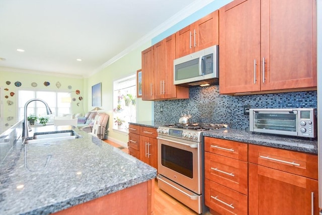 41 Oak St Unit 2, Waltham, MA 02453 - kitchen featuring appliances with stainless steel finishes, dark stone countertops, brown cabinetry, and ornamental molding