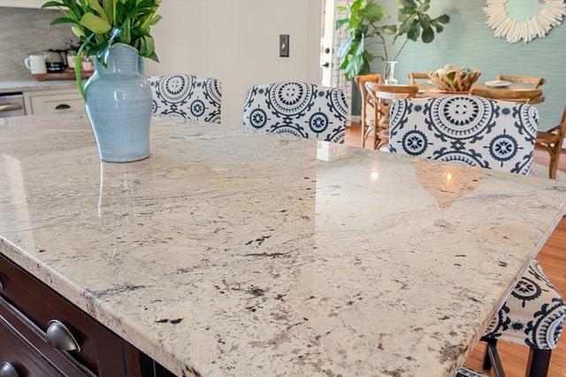 room details featuring light stone counters, white cabinets, and tasteful backsplash