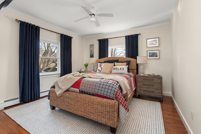 bedroom featuring crown molding, wood finished floors, and baseboard heating