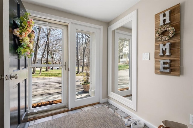 doorway to outside with baseboards and plenty of natural light