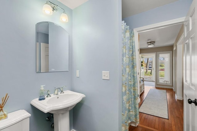 full bathroom with toilet, baseboards, and wood finished floors