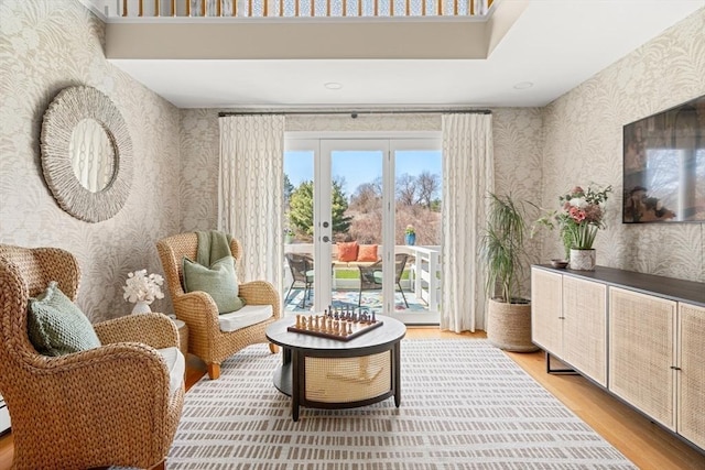 sitting room featuring light wood finished floors and wallpapered walls