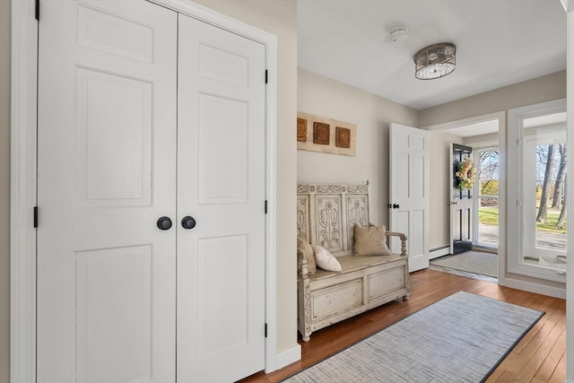 entrance foyer featuring baseboards, a baseboard heating unit, and wood finished floors