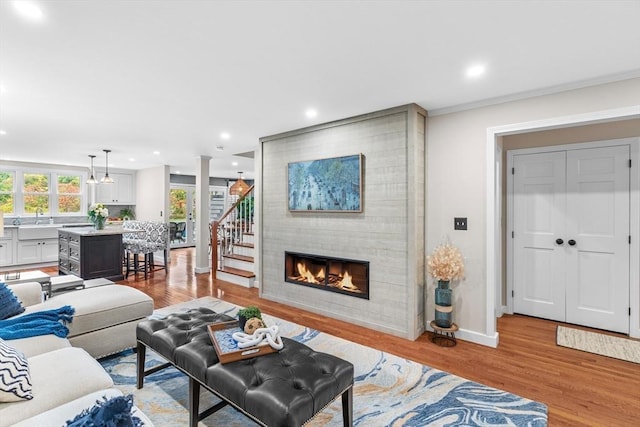 living area with baseboards, recessed lighting, and light wood-style flooring