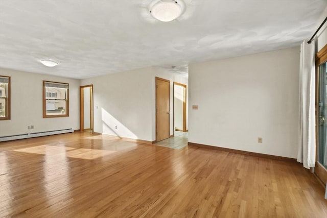 unfurnished room featuring light wood-type flooring and a baseboard radiator