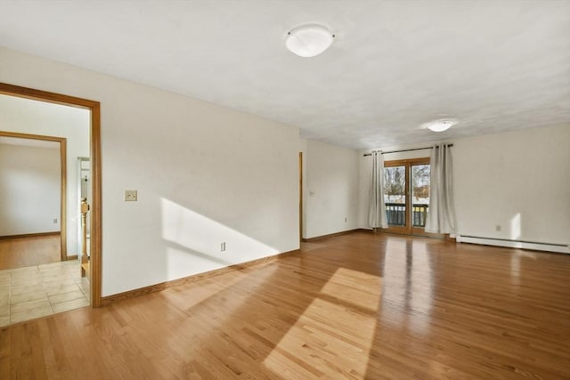 empty room with wood-type flooring and a baseboard radiator