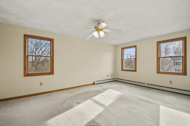 spare room with ceiling fan, light colored carpet, and a baseboard heating unit