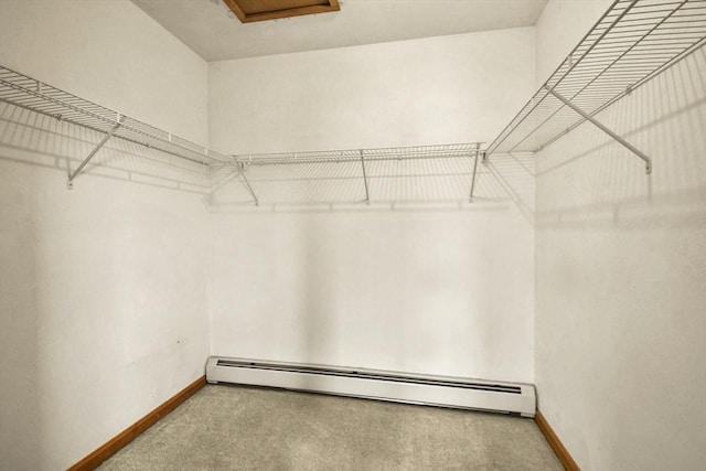 walk in closet with carpet and a baseboard heating unit