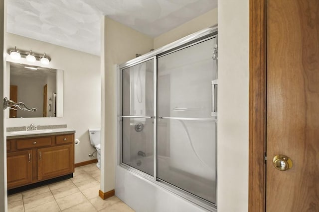 full bathroom featuring toilet, tile patterned flooring, vanity, and combined bath / shower with glass door