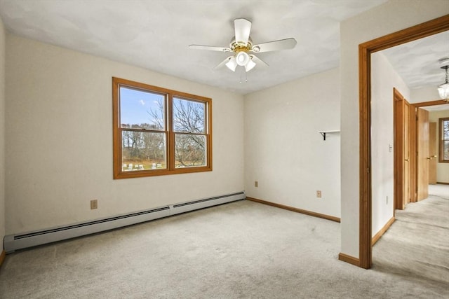 carpeted empty room featuring baseboard heating and ceiling fan