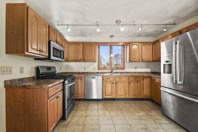 kitchen featuring sink, rail lighting, light tile patterned floors, and appliances with stainless steel finishes