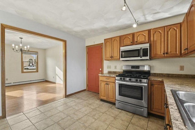 kitchen featuring an inviting chandelier, baseboard heating, light hardwood / wood-style flooring, decorative light fixtures, and appliances with stainless steel finishes