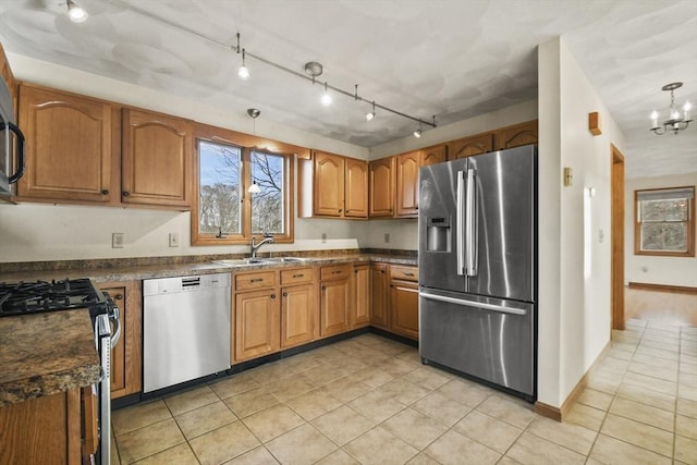 kitchen featuring sink, stainless steel appliances, hanging light fixtures, and a chandelier