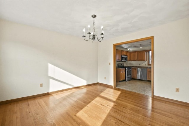 interior space with light wood-type flooring and an inviting chandelier