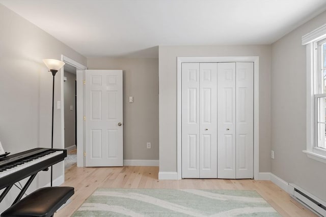 living area with light wood-style flooring, baseboards, and a baseboard radiator