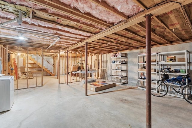 unfinished basement featuring washer / dryer and stairs