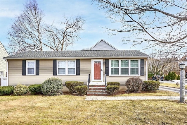 ranch-style home with a front lawn and roof with shingles