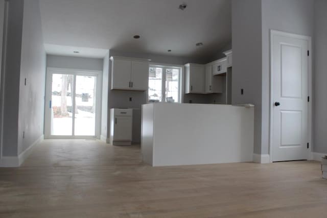 kitchen featuring light wood-style floors, baseboards, and white cabinets