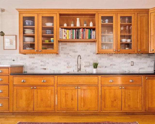 kitchen featuring sink, decorative backsplash, and light hardwood / wood-style flooring