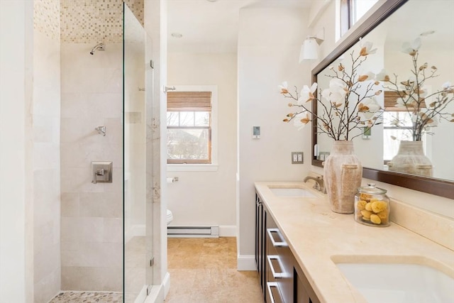 bathroom featuring vanity, toilet, tiled shower, and baseboard heating