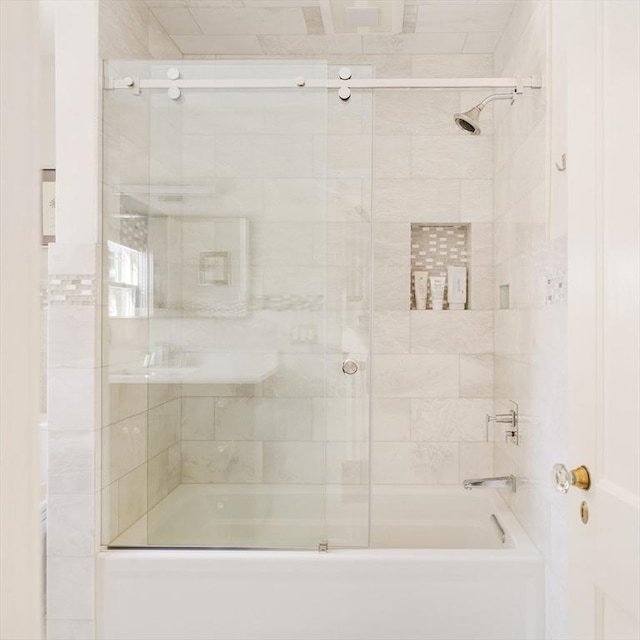 bathroom with combined bath / shower with glass door