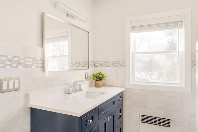 bathroom with vanity, radiator heating unit, and tile walls