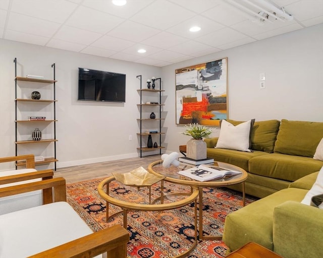 living room featuring a paneled ceiling and light hardwood / wood-style floors