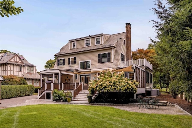 back of house featuring cooling unit, a yard, a wooden deck, and a patio area