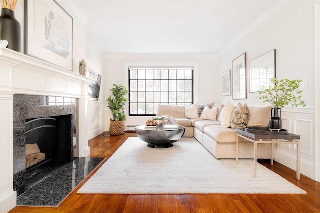 living room featuring hardwood / wood-style flooring, ornamental molding, a fireplace, and a baseboard radiator