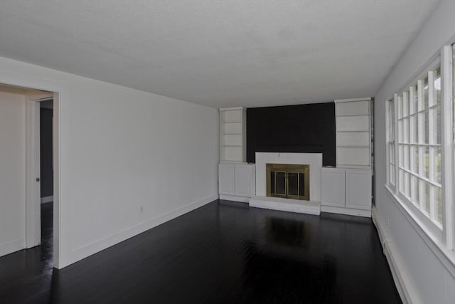 7 Summit Dr, Westfield, MA 01085 - unfurnished living room featuring a fireplace, dark wood-style floors, built in shelves, and a textured ceiling