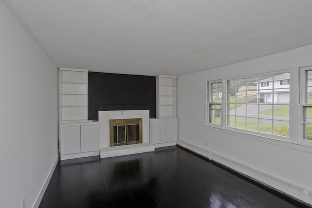 7 Summit Dr, Westfield, MA 01085 - unfurnished living room featuring dark wood-style flooring, a large fireplace, built in features, and a textured ceiling
