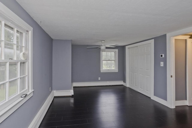 7 Summit Dr, Westfield, MA 01085 - empty room with dark wood-style flooring, ceiling fan, and a baseboard heating unit