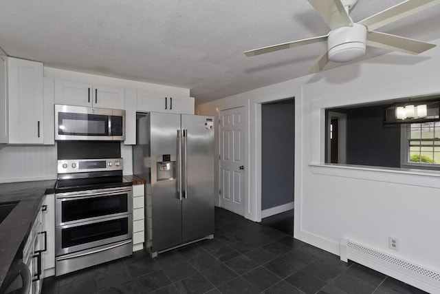 7 Summit Dr, Westfield, MA 01085 - kitchen with appliances with stainless steel finishes, baseboard heating, white cabinetry, dark countertops, and a textured ceiling