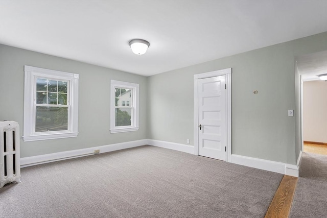 2 Howard St, Braintree, MA 02184 - carpeted spare room with radiator heating unit and baseboards