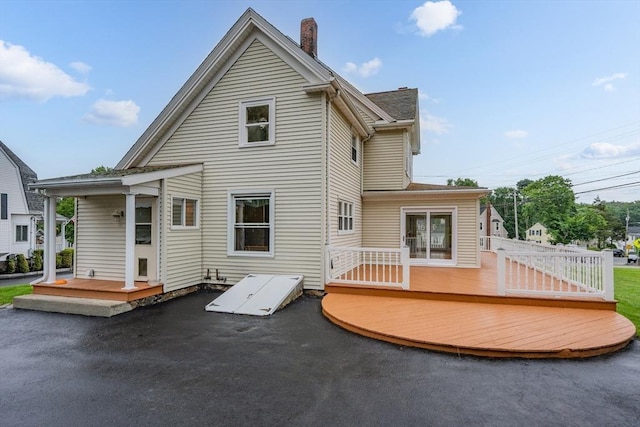 2 Howard St, Braintree, MA 02184 - back of property with a wooden deck, a chimney, and a patio area