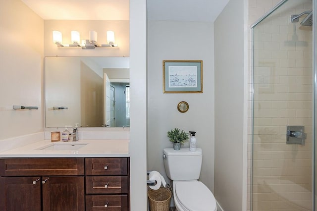 bathroom with a shower with door, vanity, and toilet