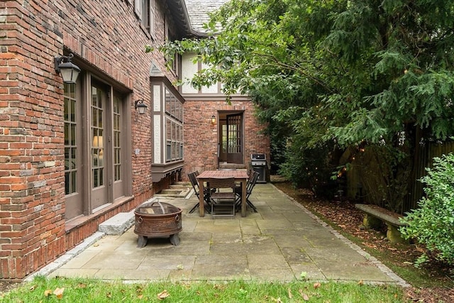 view of patio / terrace with entry steps, a fire pit, and area for grilling