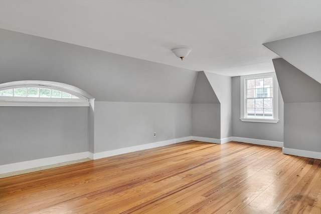 bonus room featuring vaulted ceiling, baseboards, and wood finished floors