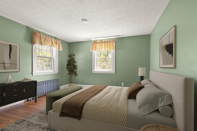 4 Grand St, Reading, MA 01867 - bedroom with radiator heating unit, multiple windows, wood finished floors, and a textured ceiling