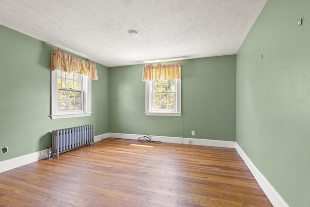 4 Grand St, Reading, MA 01867 - spare room with radiator, wood finished floors, and a textured ceiling
