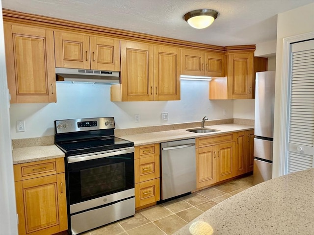 kitchen featuring under cabinet range hood, a sink, appliances with stainless steel finishes, and light tile patterned flooring