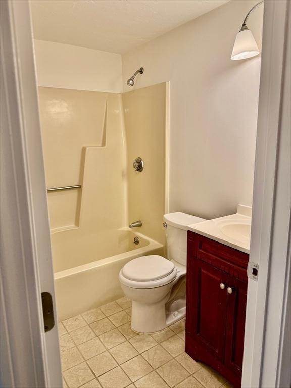 bathroom with shower / bathtub combination, tile patterned floors, vanity, and toilet