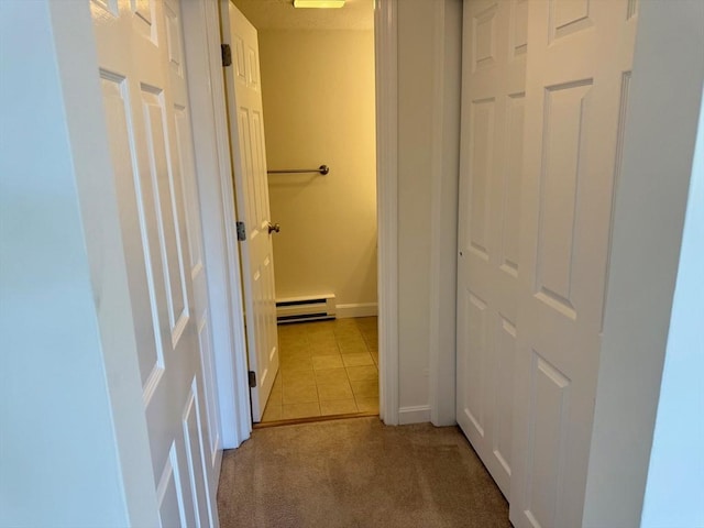 hallway featuring light tile patterned floors, light carpet, baseboards, and a baseboard radiator